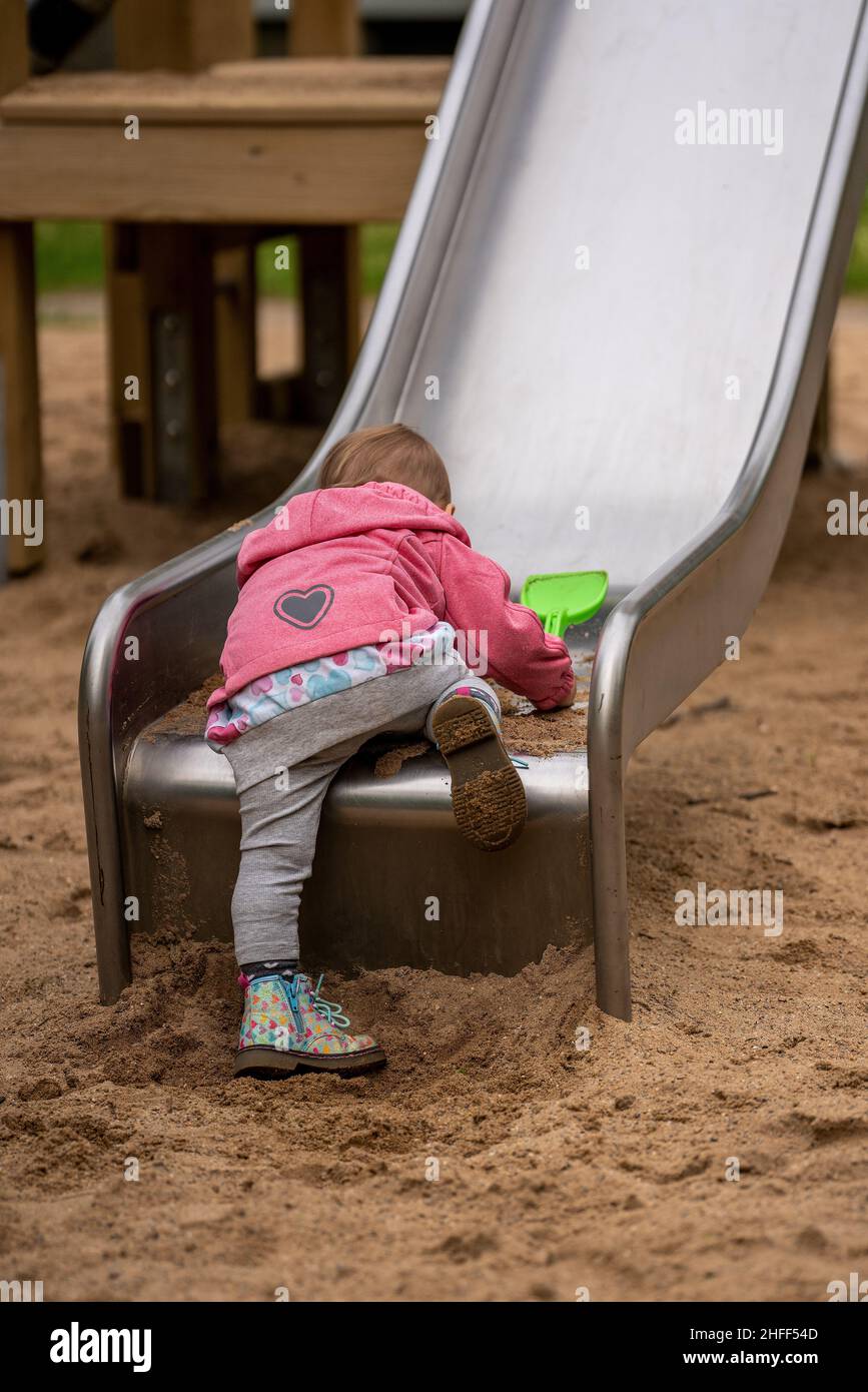 little girl on a slide in the playground Stock Photo