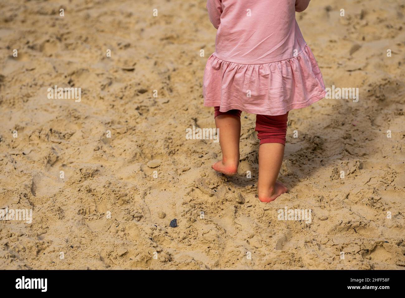 A little child barefoot in the sand Stock Photo