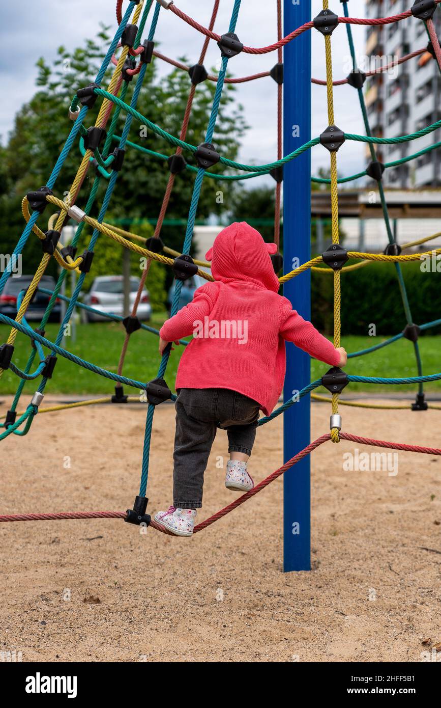 A small child on the jungle gym with net in a playground Stock Photo