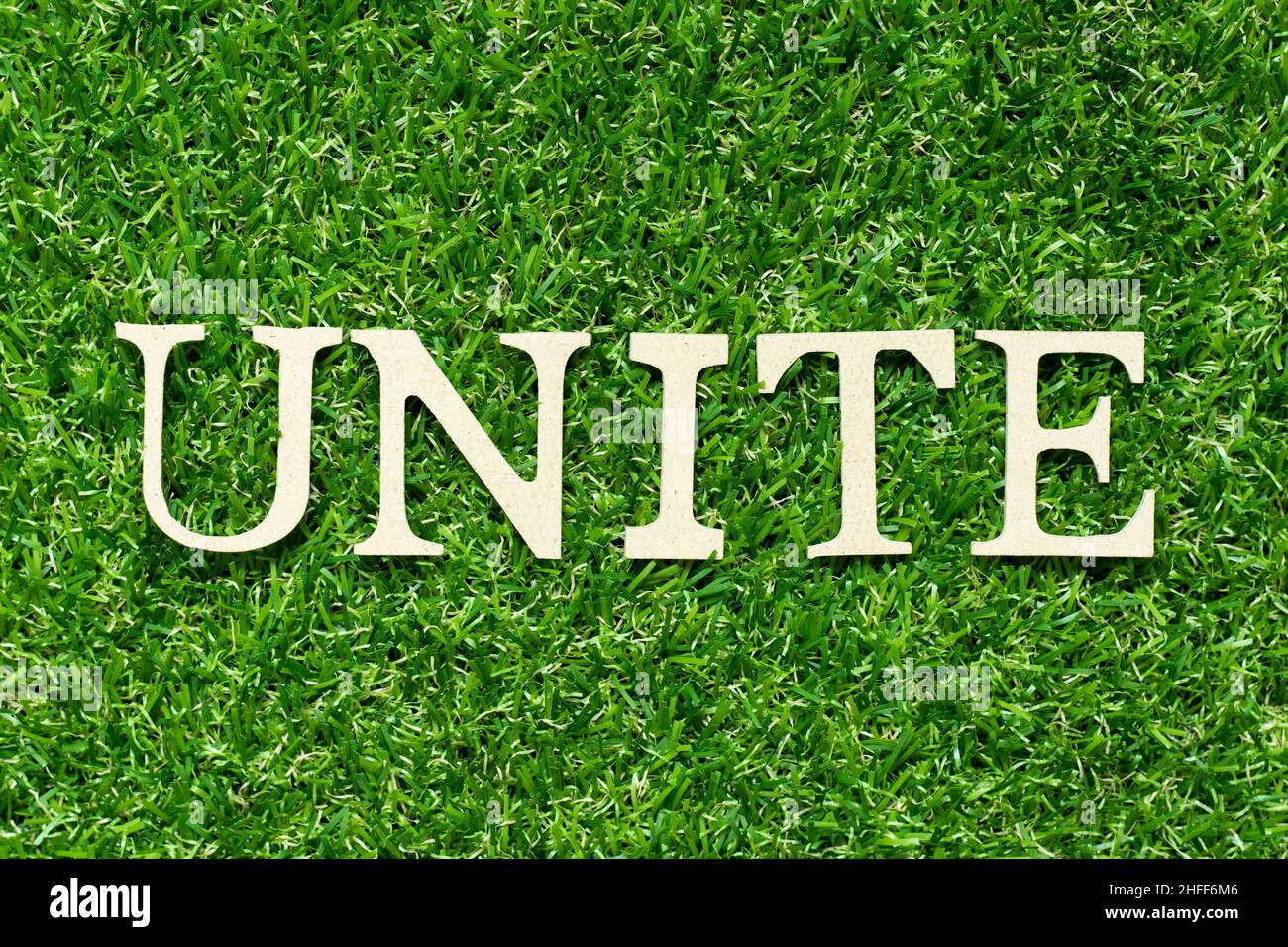 Wood letter in word unite on green grass background Stock Photo Alamy