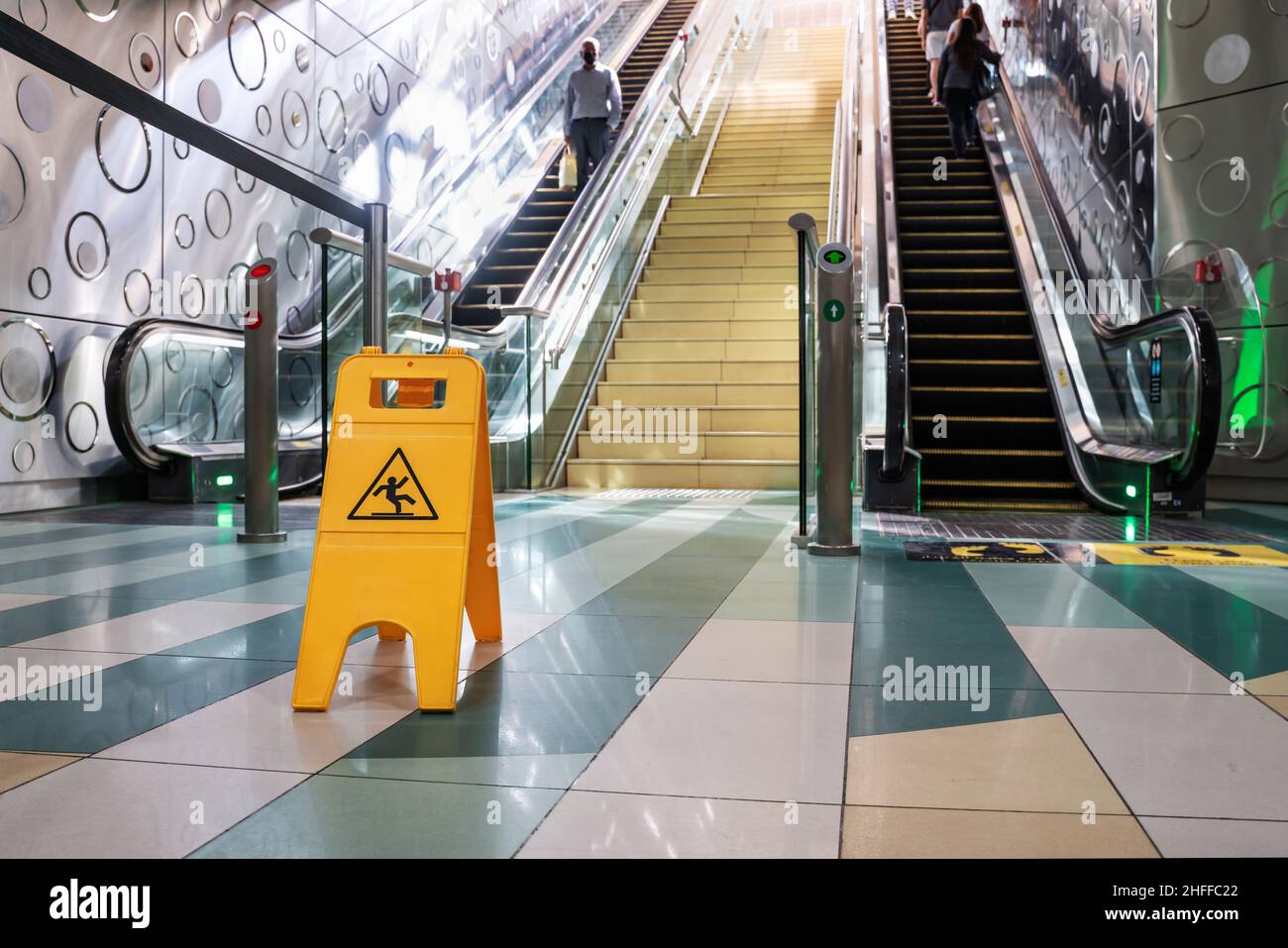 Caution. yellow wet floor sign in front of the escalator. Selective focus Stock Photo