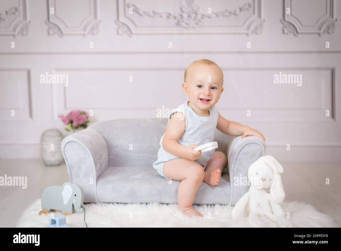 Little girl sitting on sofa with a teddy bear Stock Photo - Alamy