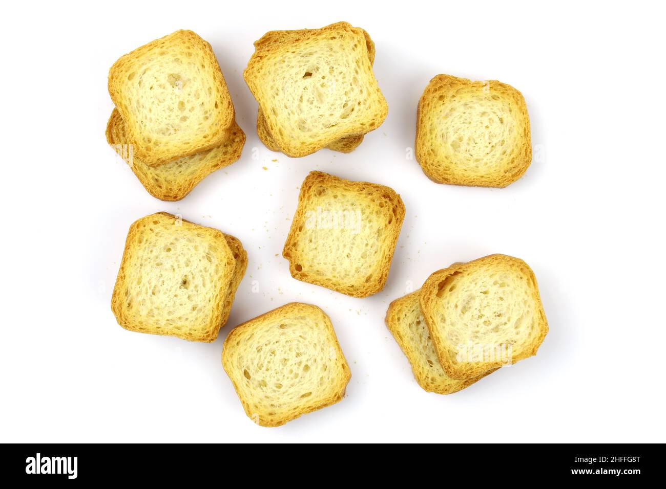 Square white bread croutons top view. Croutons on a white background. Wheat mini croutons for snacks. Stock Photo