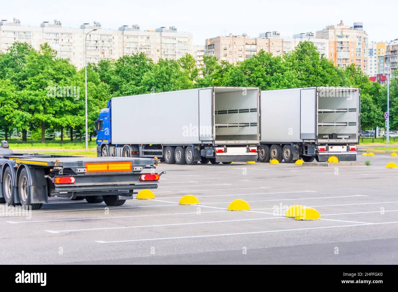 Trucks with open container trailers in the parking lot of the warehouse ...