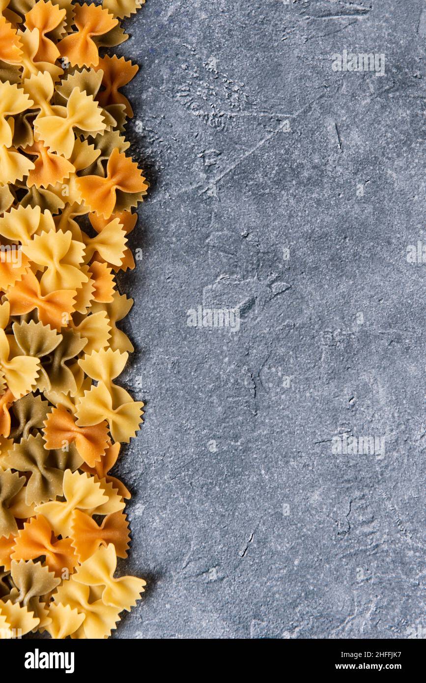 Colorful farfalle pasta on stone background with copy space Stock Photo