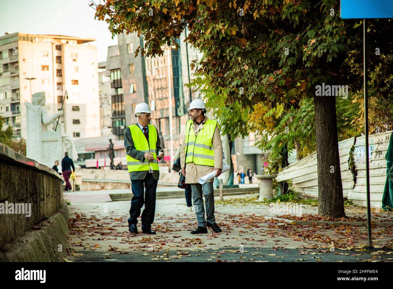 Two construction workers are walking together while talking Stock Photo