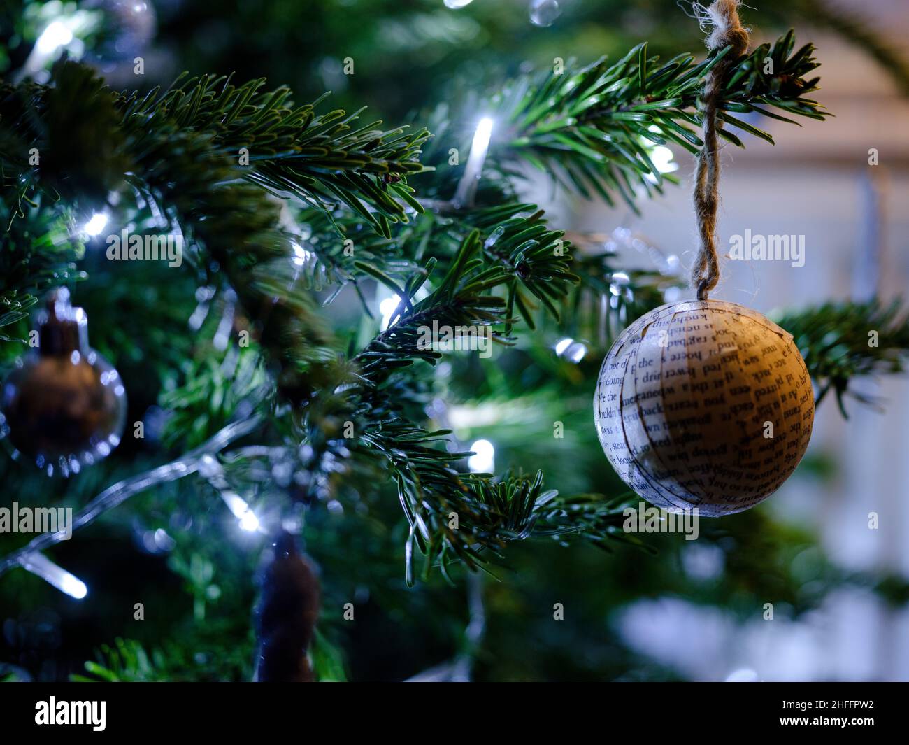 A handmade Christmas bauble made from recycled book pages hanging on a Norway Spruce Christmas Tree  on Monday, Dec. 27, 2021. Stock Photo