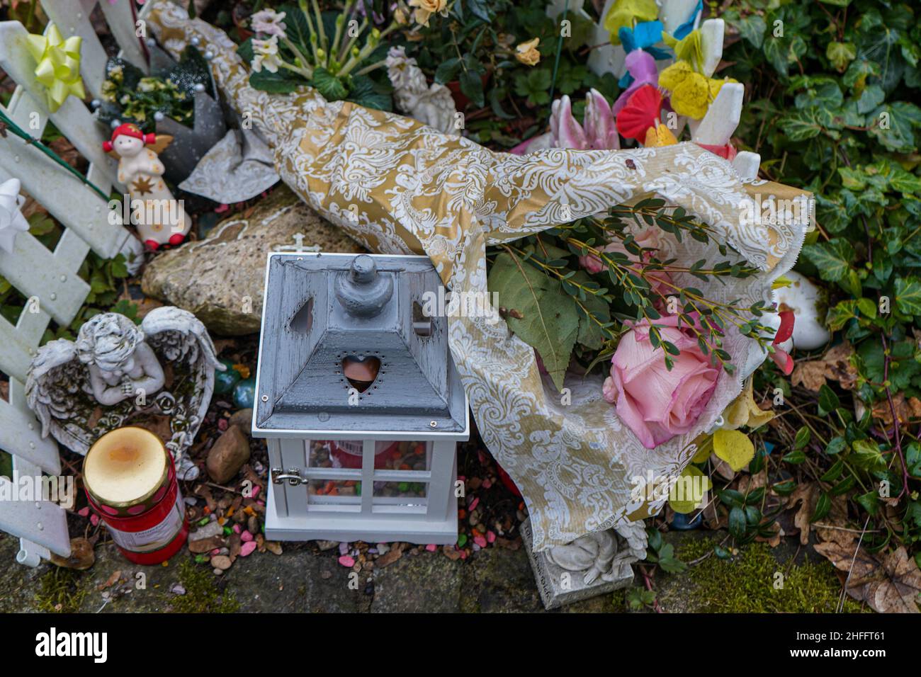 A grave for a child or a fetus at the Waldfriedhof cemetery in Munich. Relatives placed a pink rose on a child's grave. Stock Photo