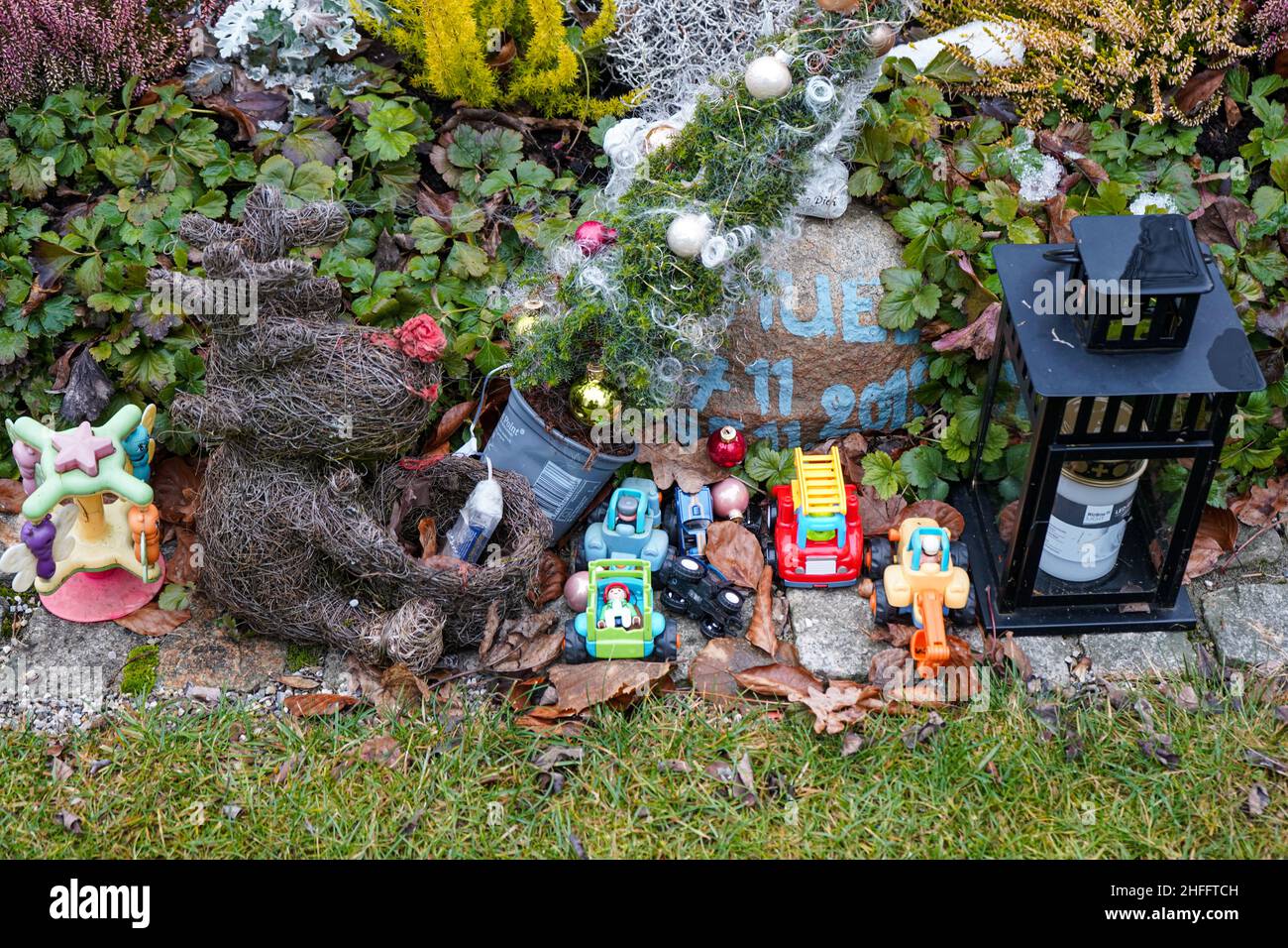 A grave for a child or a fetus at the Waldfriedhof cemetery in Munich.  Small toy cars are on the grave as grave decorations. Stock Photo