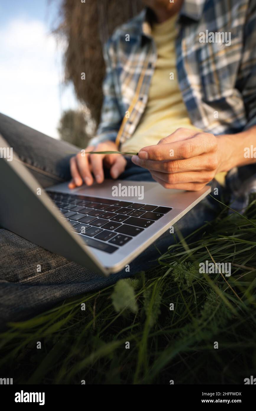 Farmer with laptop on the field. Smart farming and agriculture digitalization  Stock Photo