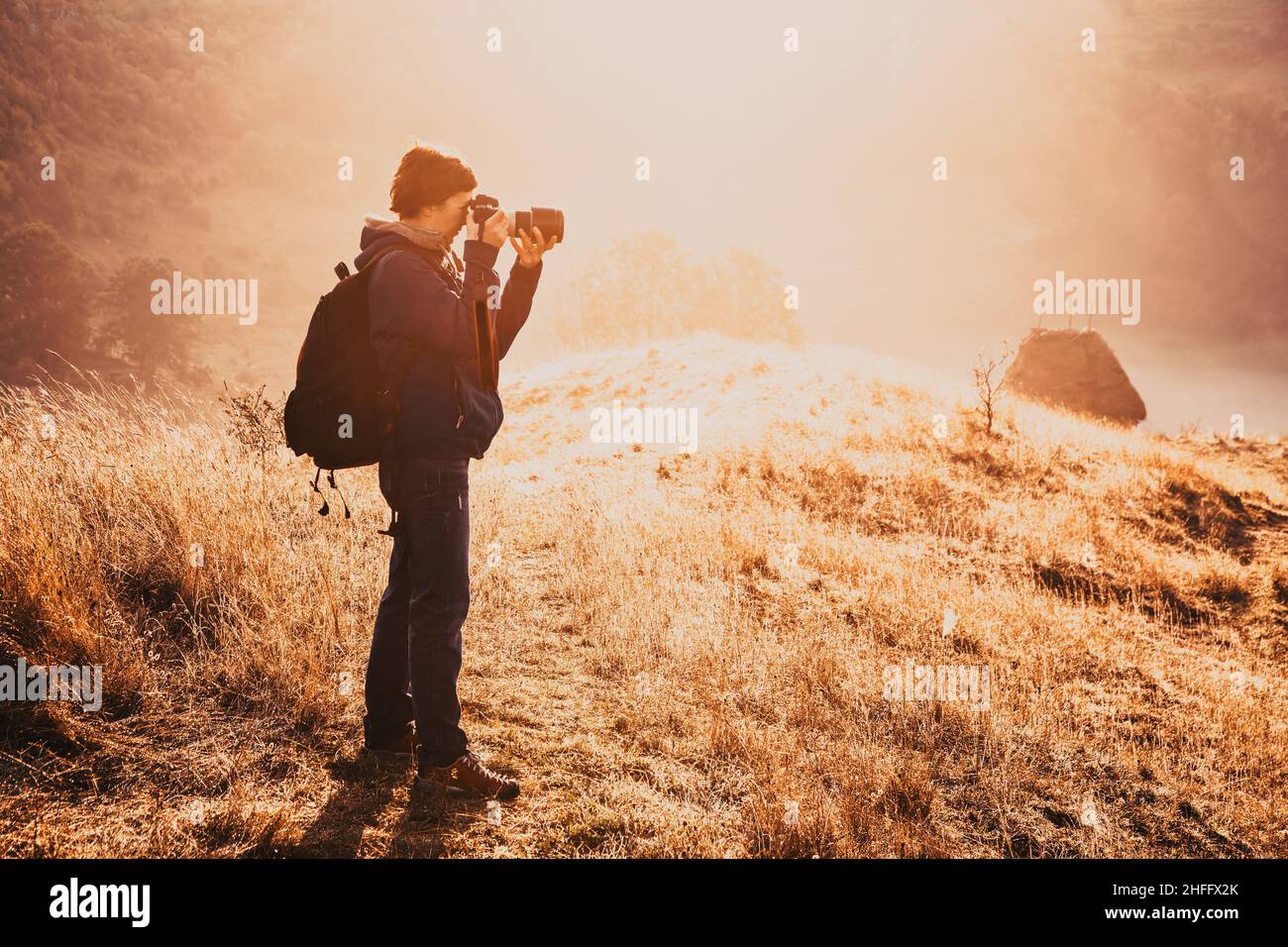 landscape photographer in a beautiful foggy morning sunrise Stock Photo