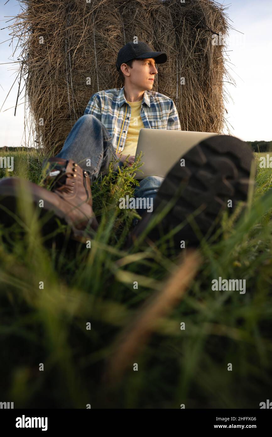 Farmer with laptop on the field. Smart farming and agriculture digitalization  Stock Photo
