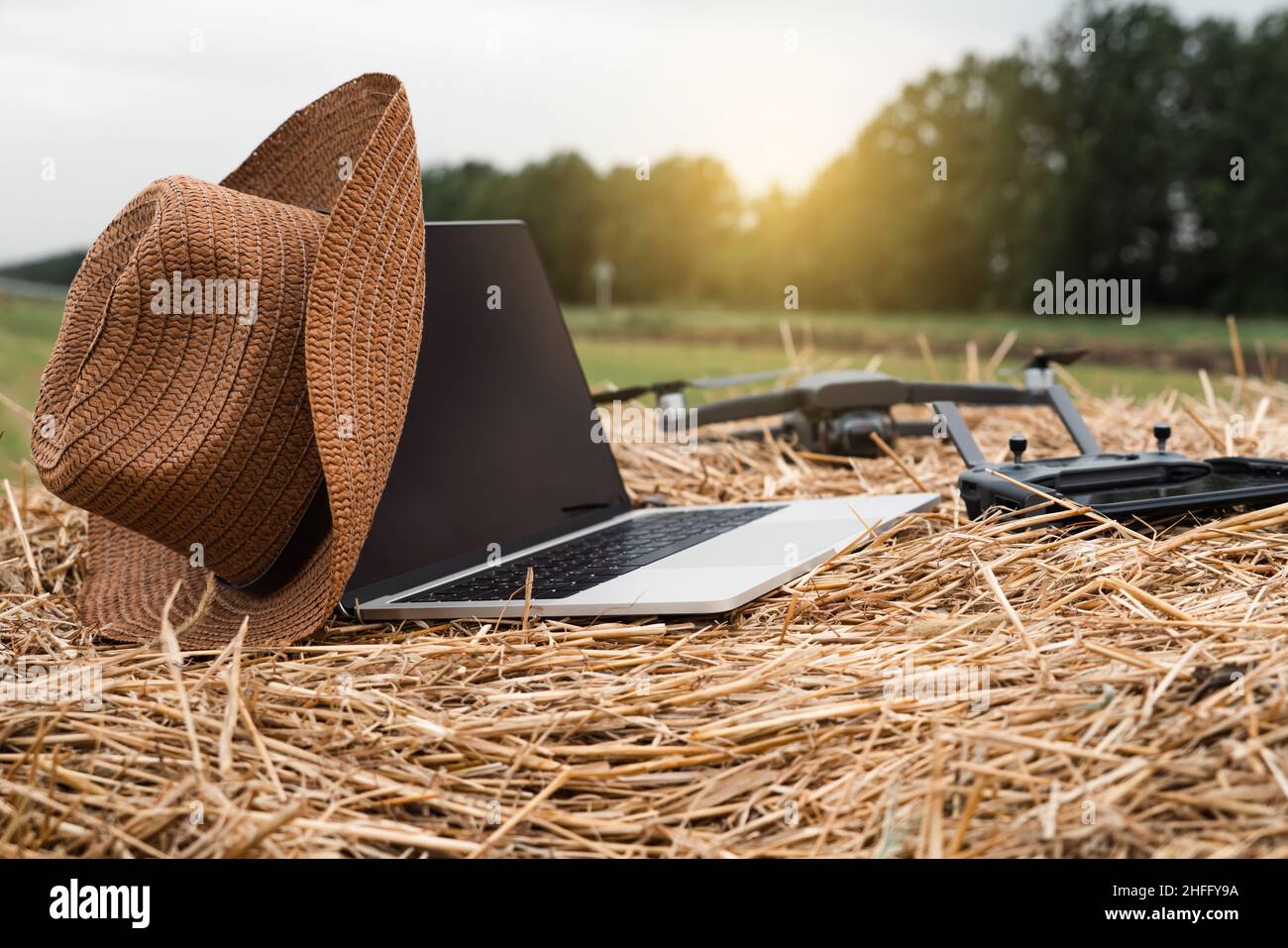Laptop with cowboy hat and drone on the hay. Smart farming and agriculture digitalization Stock Photo
