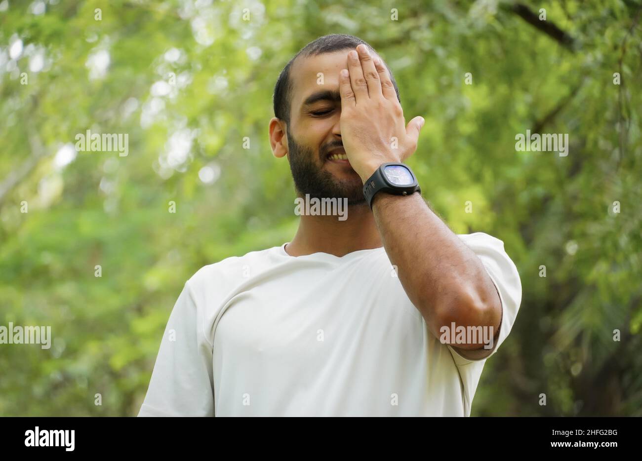 a man feels shy and happy covers his face Stock Photo