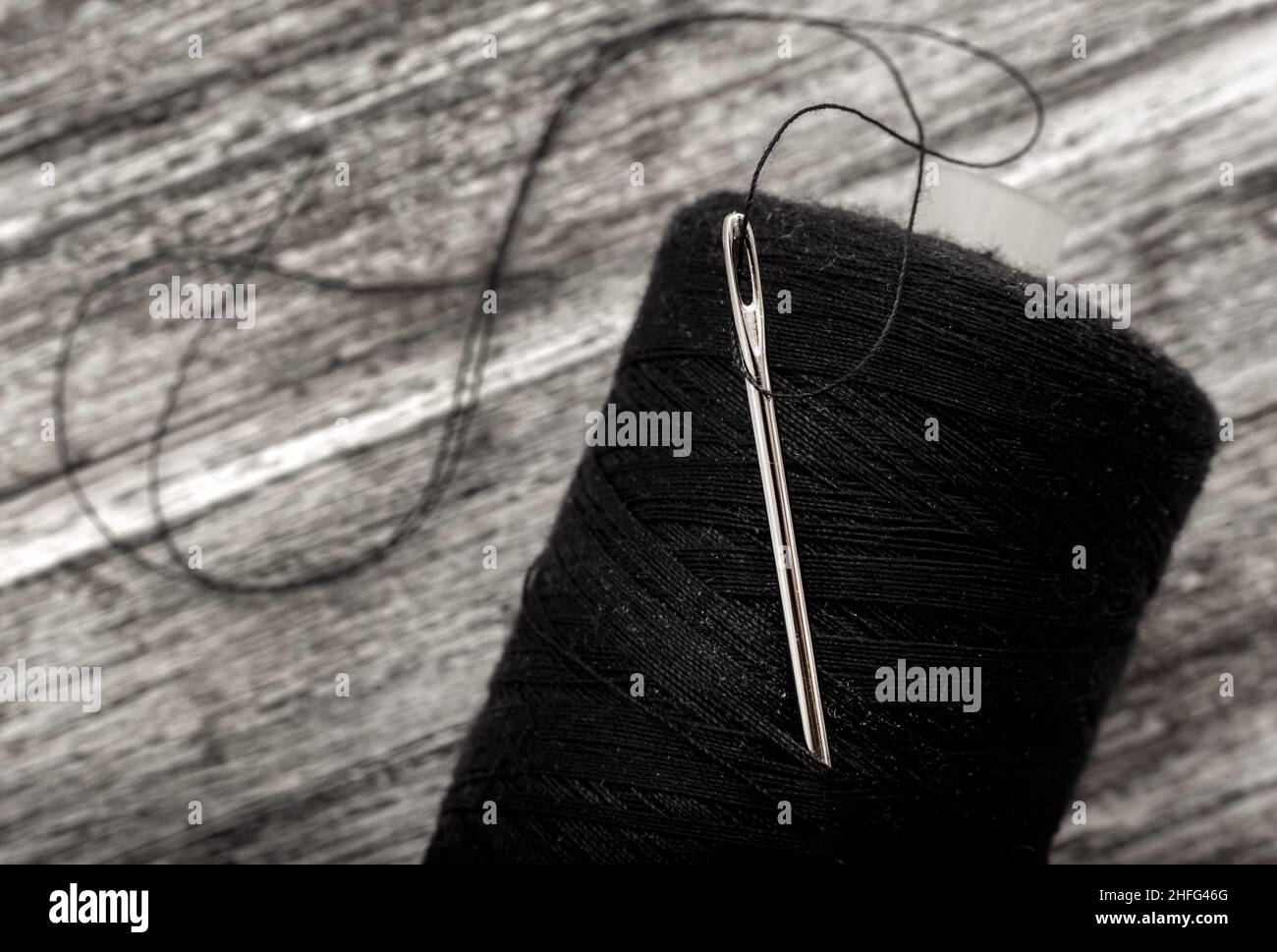 Black Thread with a Needle on an Ancient Antique Old Wooden Coil