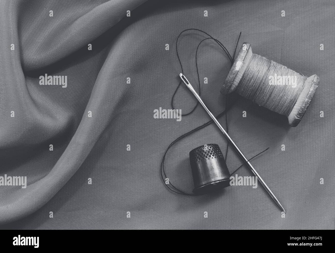 Vintage retro spool of thread on a black and white fabric background