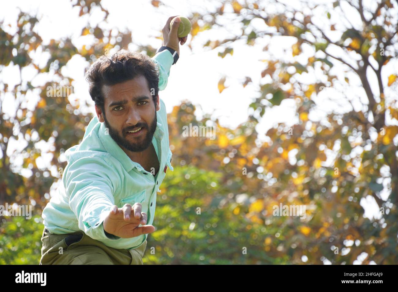 throwing Ball - Man With Cricket Ball while Playing Cricket Stock Photo