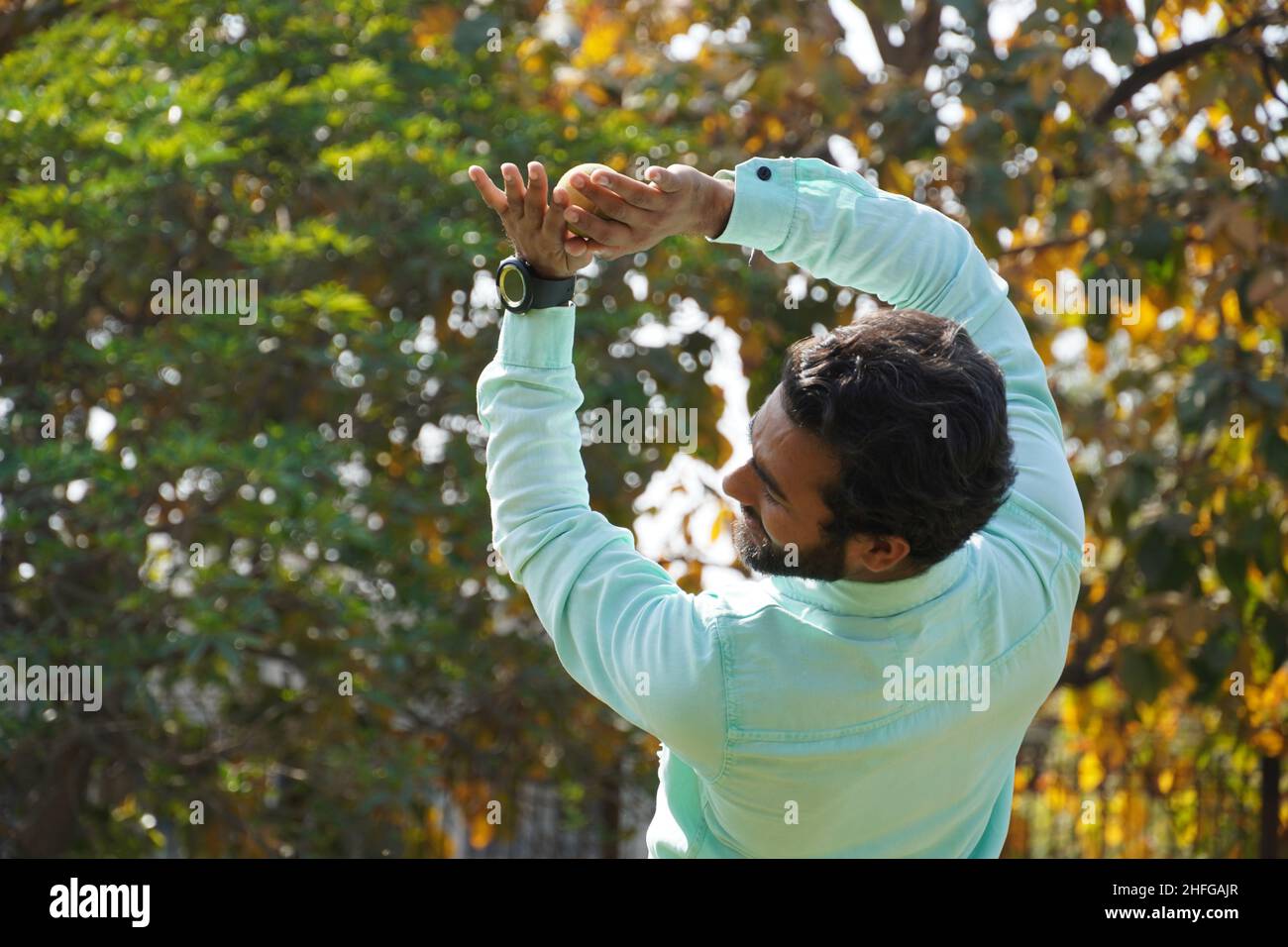 Indian man in action of catching ball in cricket match Stock Photo