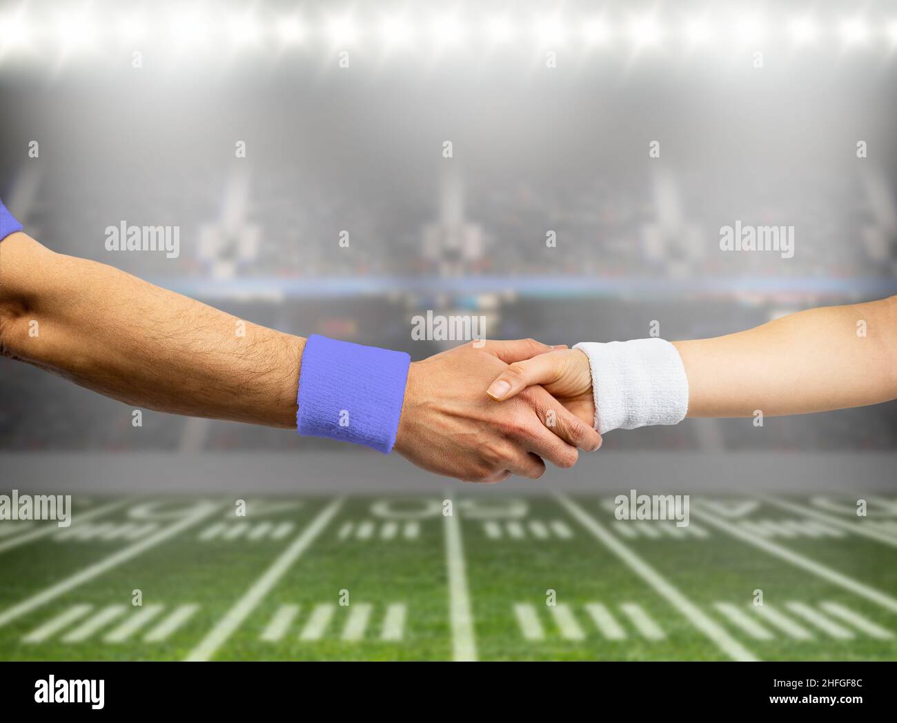 Closeup shot of two rugby players from opposite teams shaking hands Stock Photo