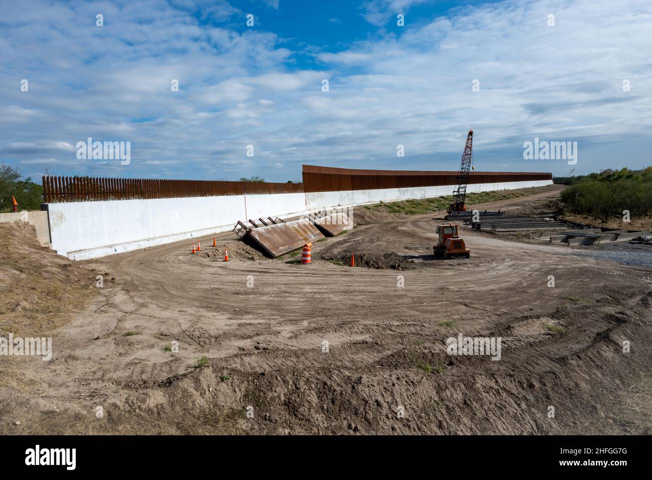 The steel and concrete US-Mexico border wall under construction along the Rio Grande. McAllen, Texas, USA. Stock Photo