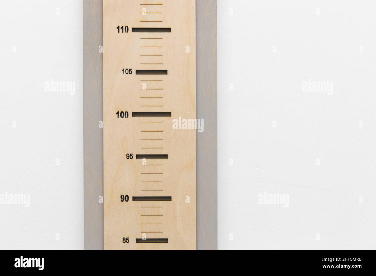 Ruler height measure child height scale size against a white wall. Stock Photo