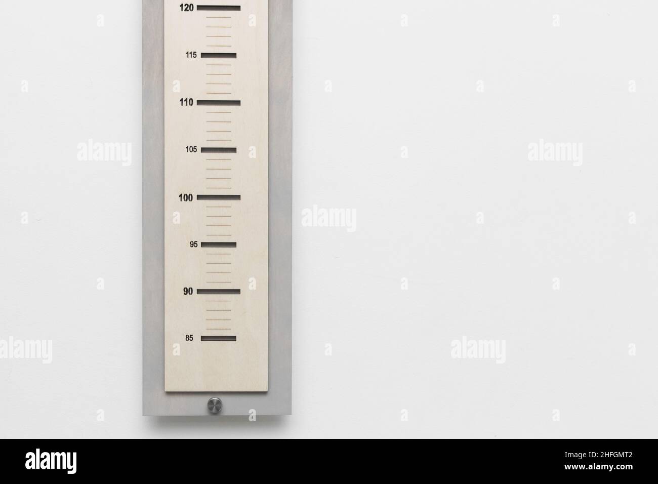 Ruler height measure child height scale size against a white wall. Stock Photo