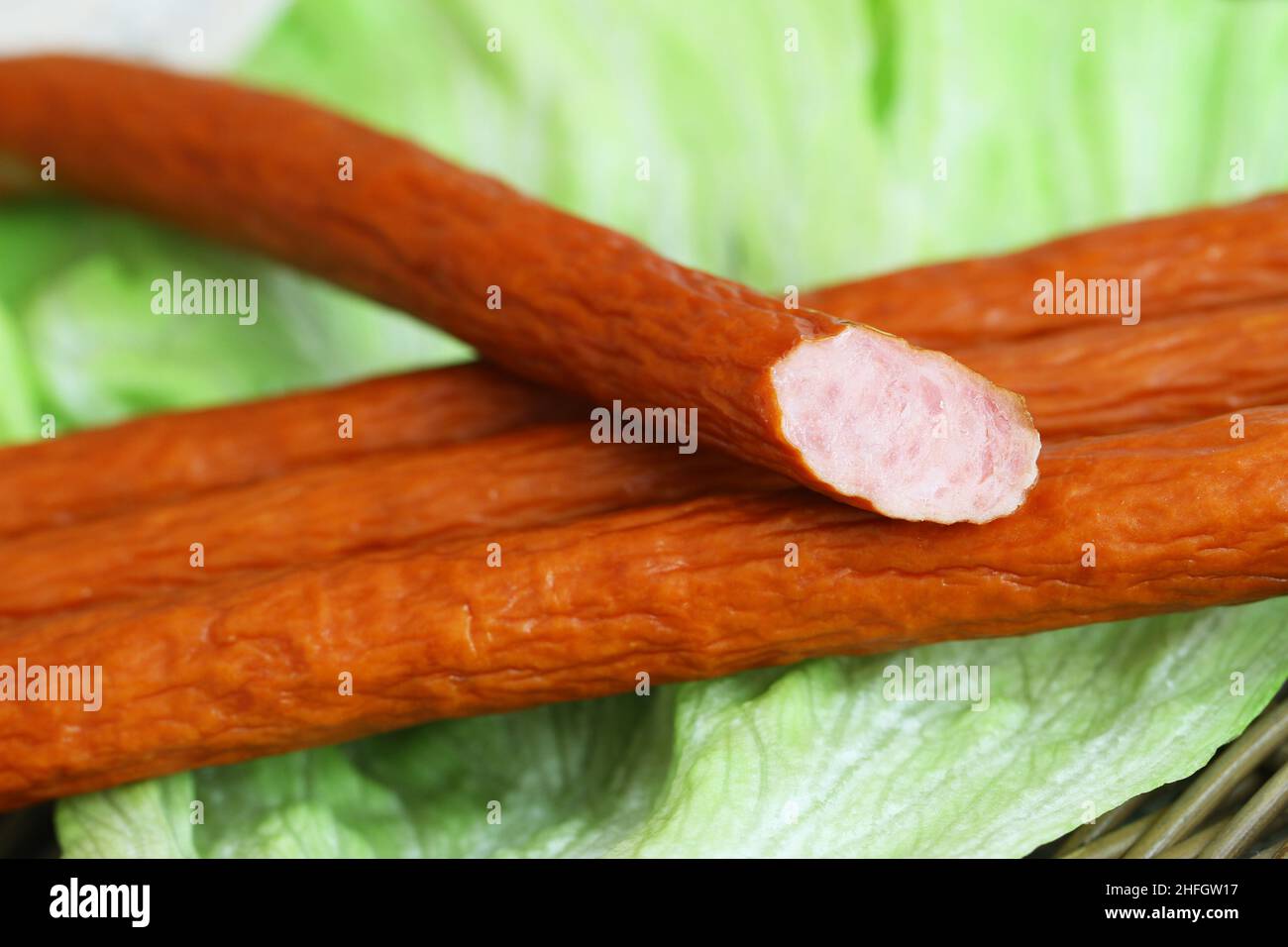 Traditional Polish smoked sausage called kabanos on lettuce leaves Stock Photo