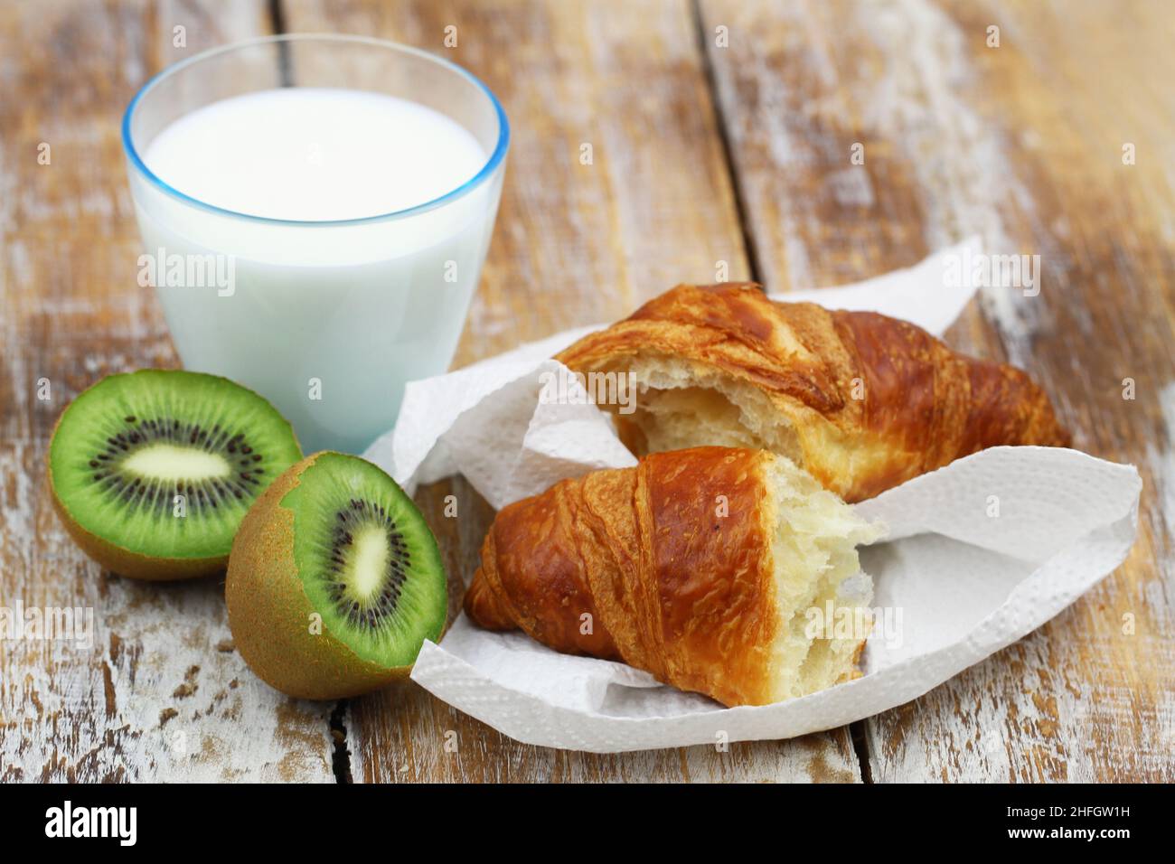 Continental breakfast: French croissant, kiwi fruit and glass of milk Stock Photo