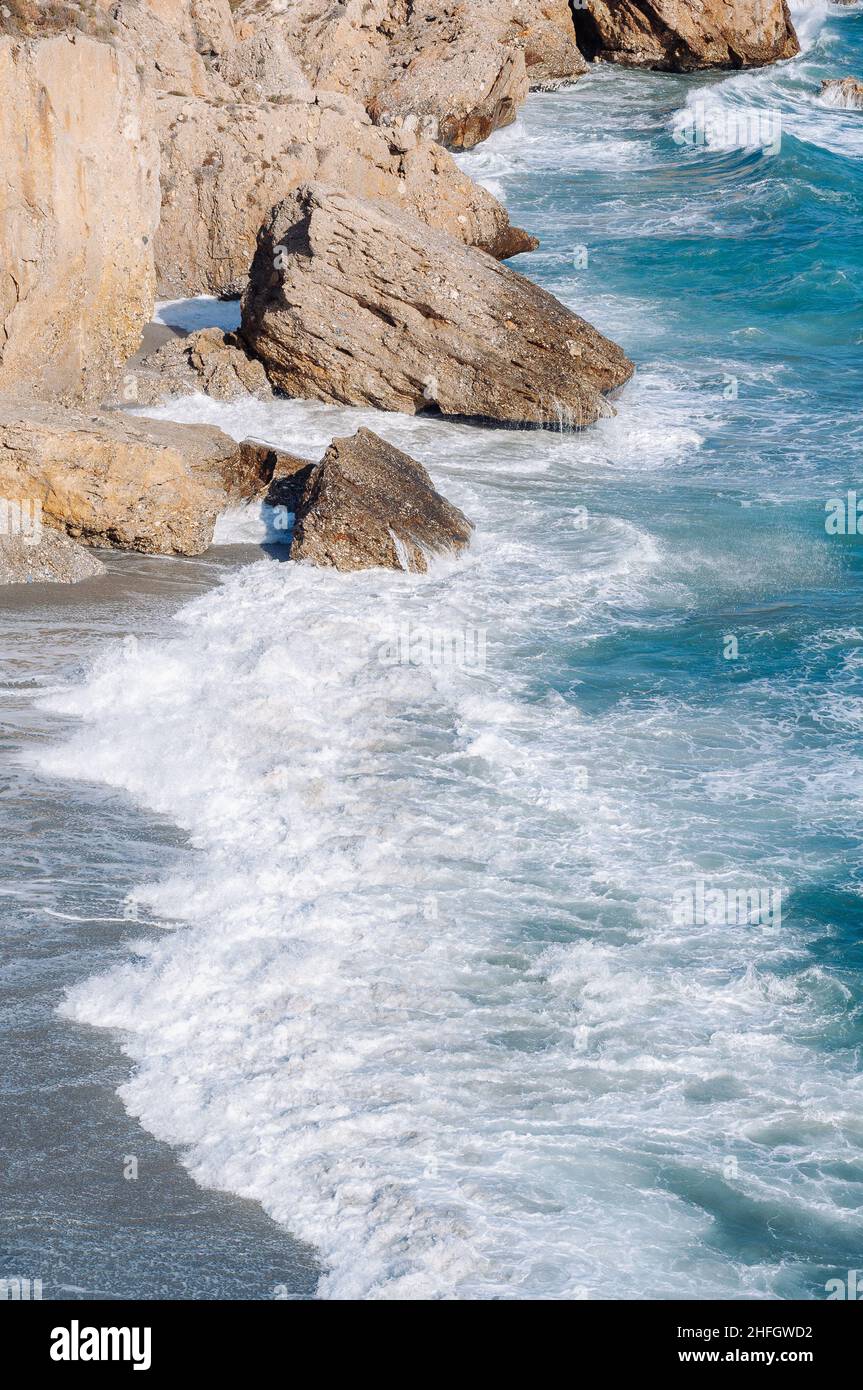 Aerial top view of sea waves hitting rocks on the beach with turquoise ...