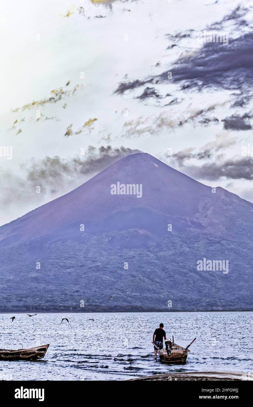 Volcan Momotombo with shore birds and a fisherman in the foreground, several days after the volcano became active after last activity in the early 20t Stock Photo