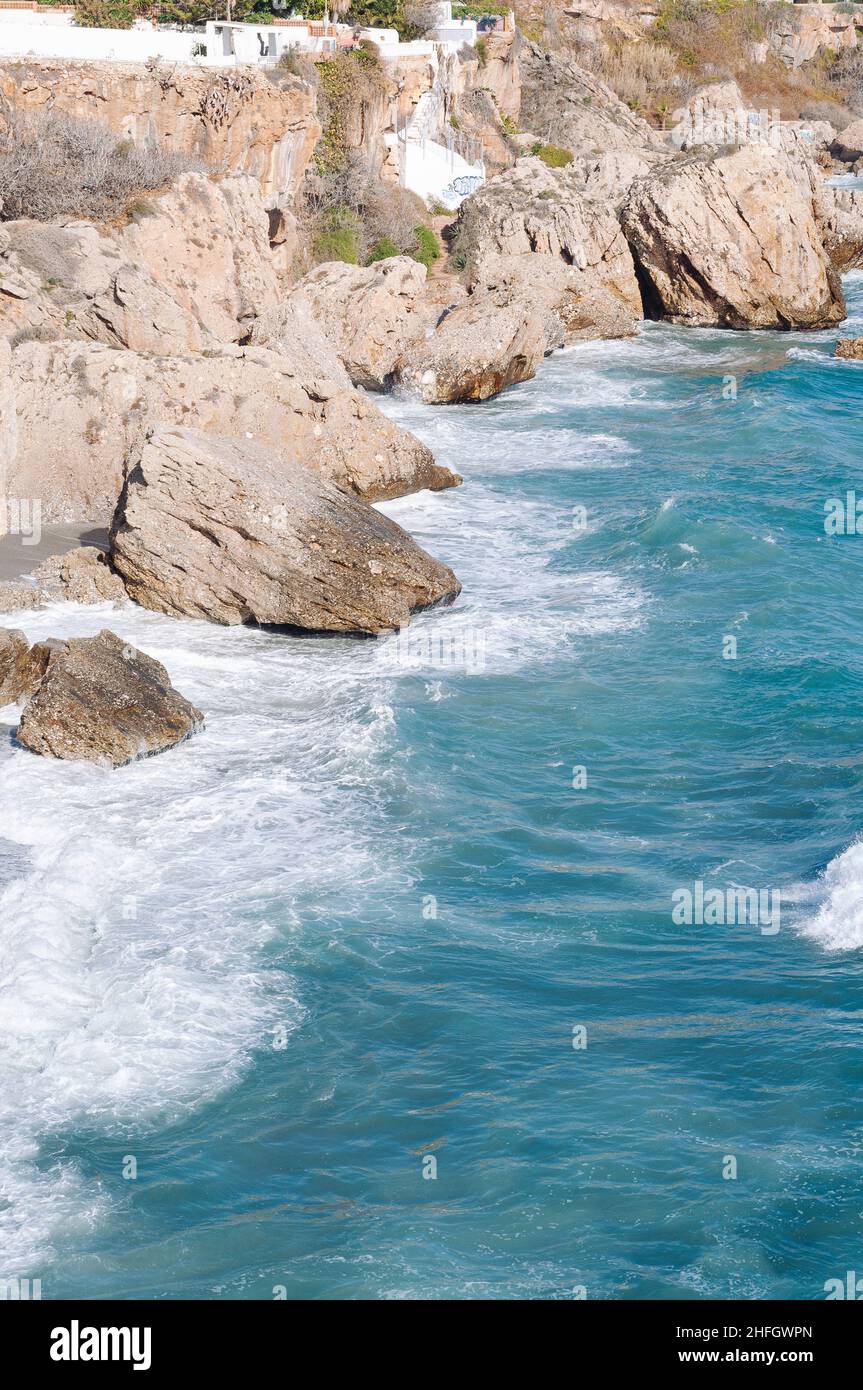 Aerial top view of sea waves hitting rocks on the beach with turquoise ...