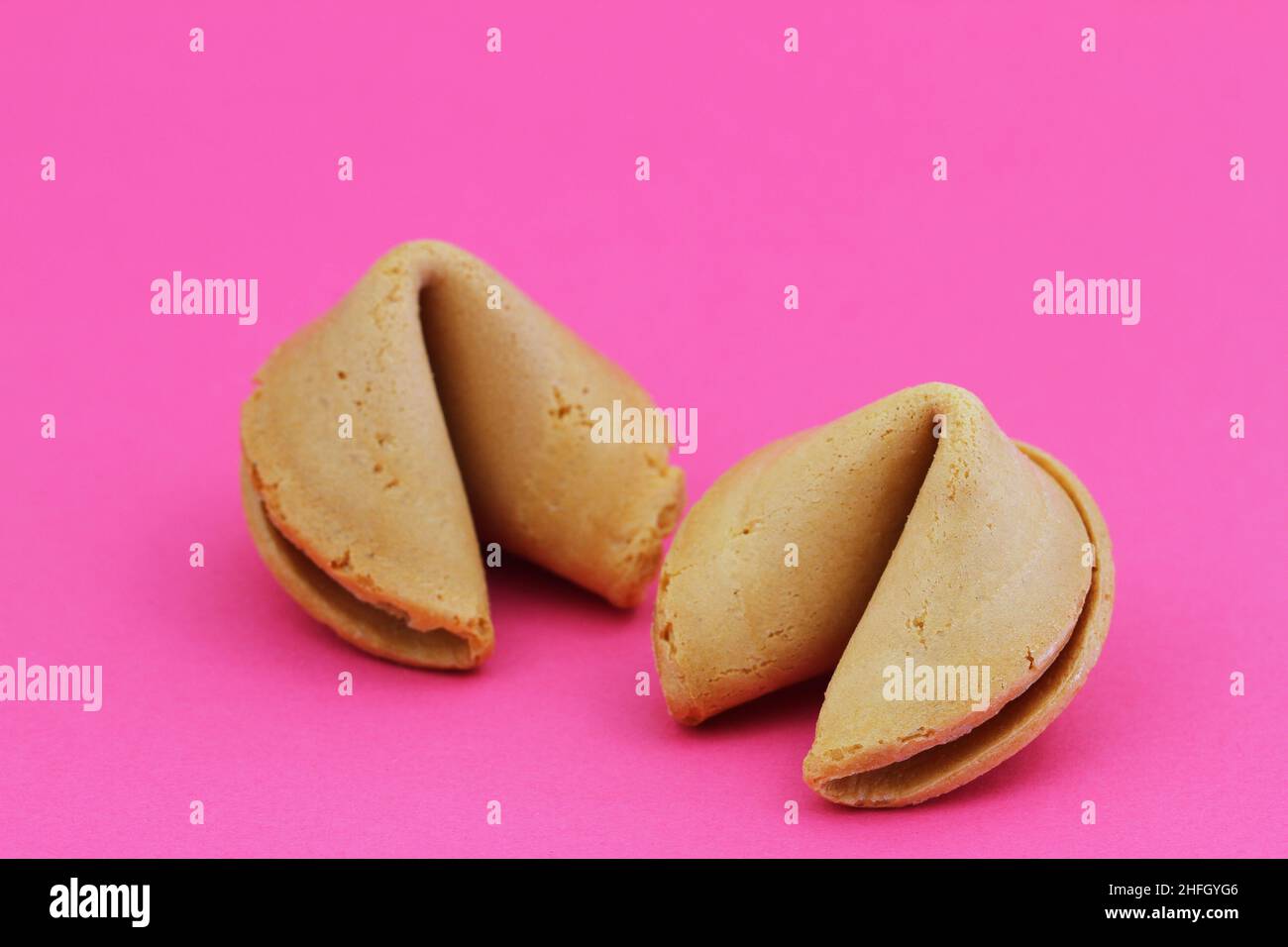Two Chinese fortune cookies on vivid pink surface with copy space Stock Photo