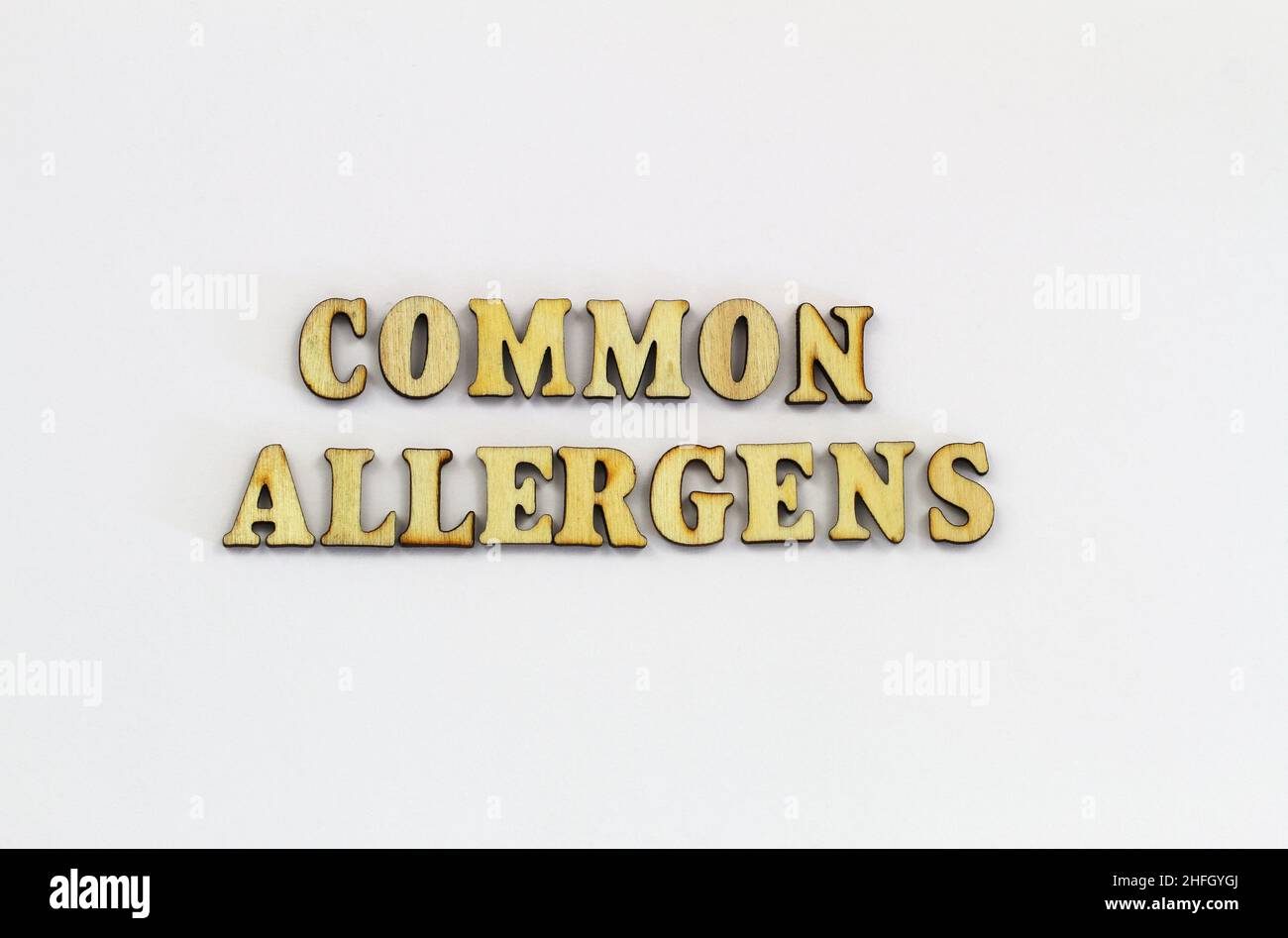 Common allergens written with wooden letters on white surface Stock Photo