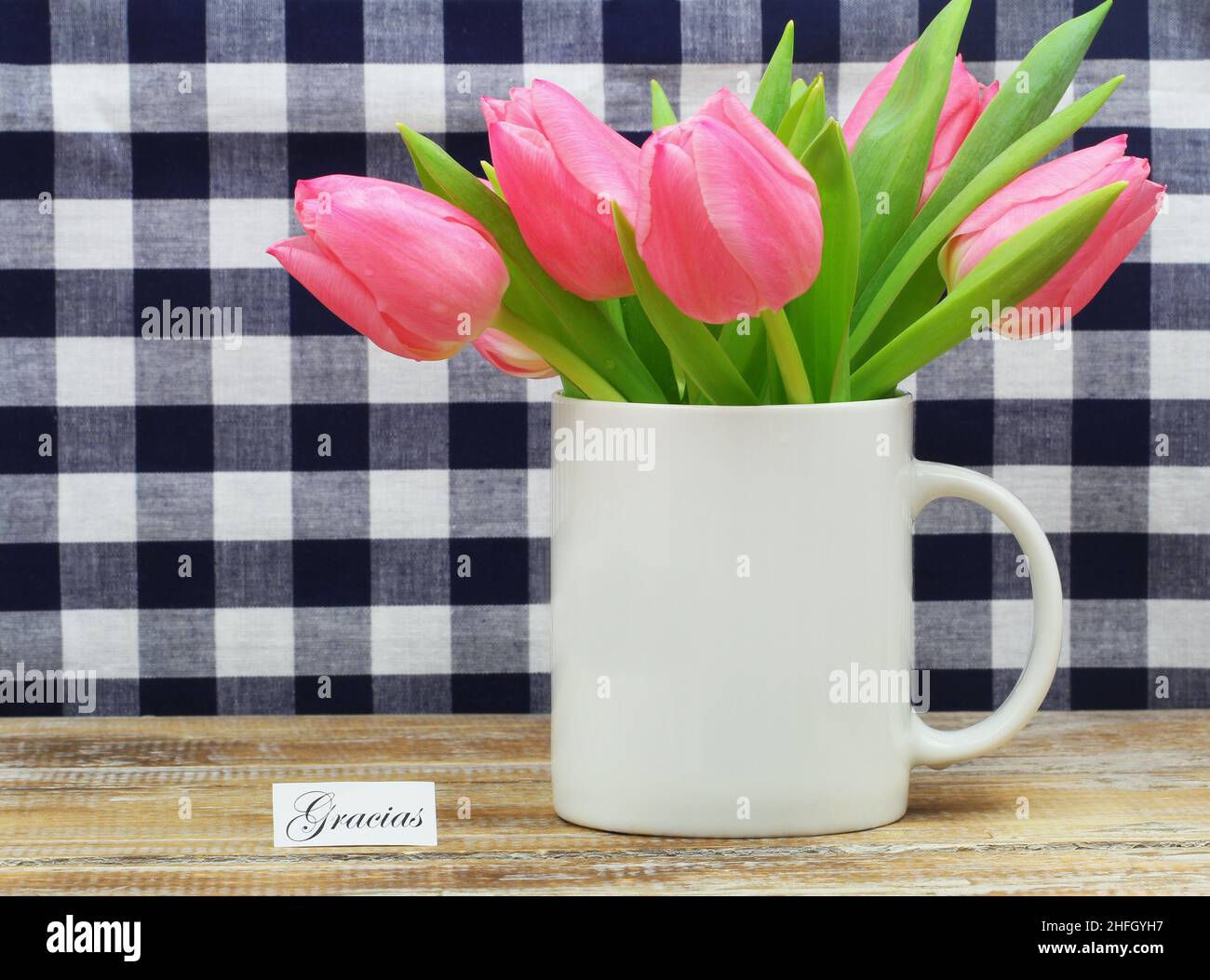 Gracias (thank you in Spanish) card with mug full of pink tulips Stock Photo