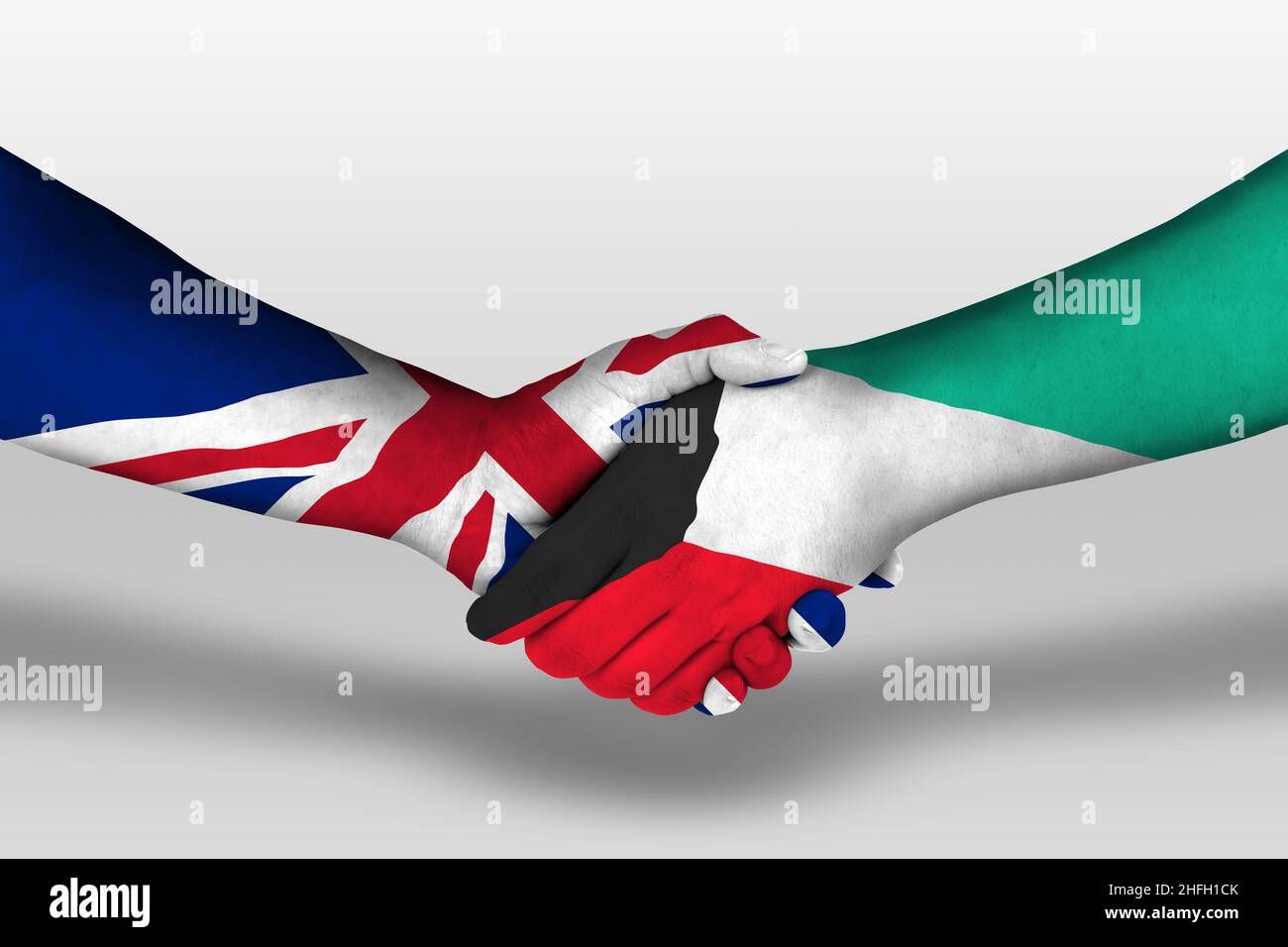 Handshake between kuwait and united kingdom flags painted on hands, illustration with clipping path. Stock Photo