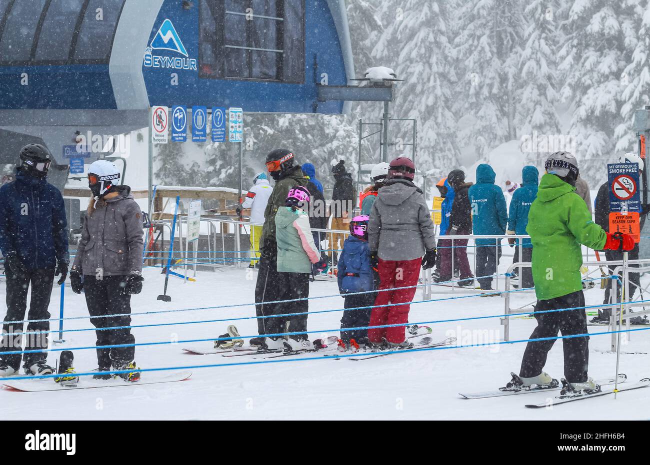 Skiers in ski region standing in line in front of a lift station at Mt Seymour Ski Resort BC, Canada-February 4,2021. Street view, travel photo, Stock Photo
