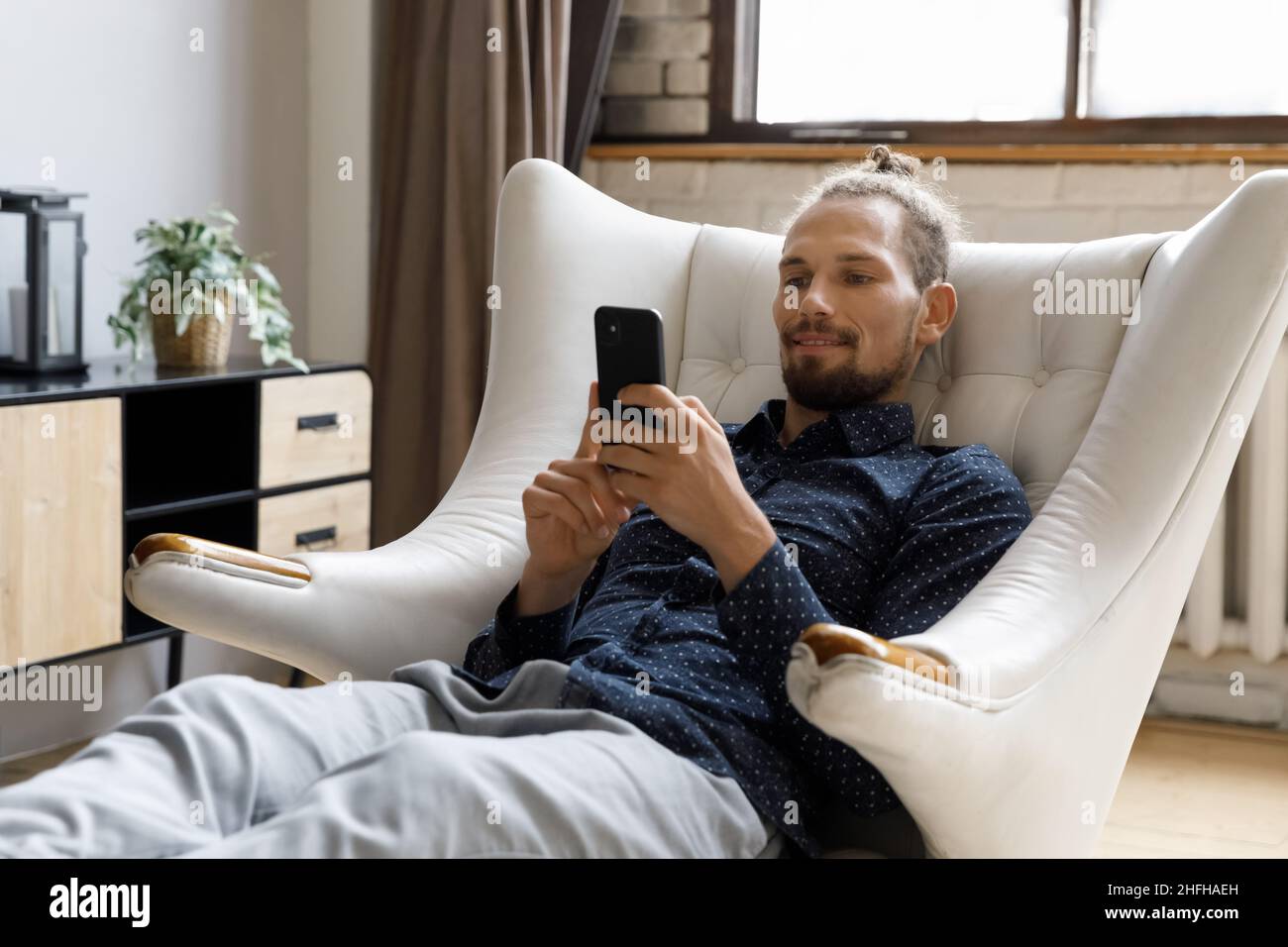 Happy handsome young hipster man using cellphone apps. Stock Photo