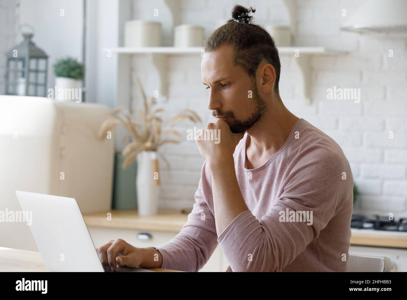 Pensive young hipster man working on computer. Stock Photo
