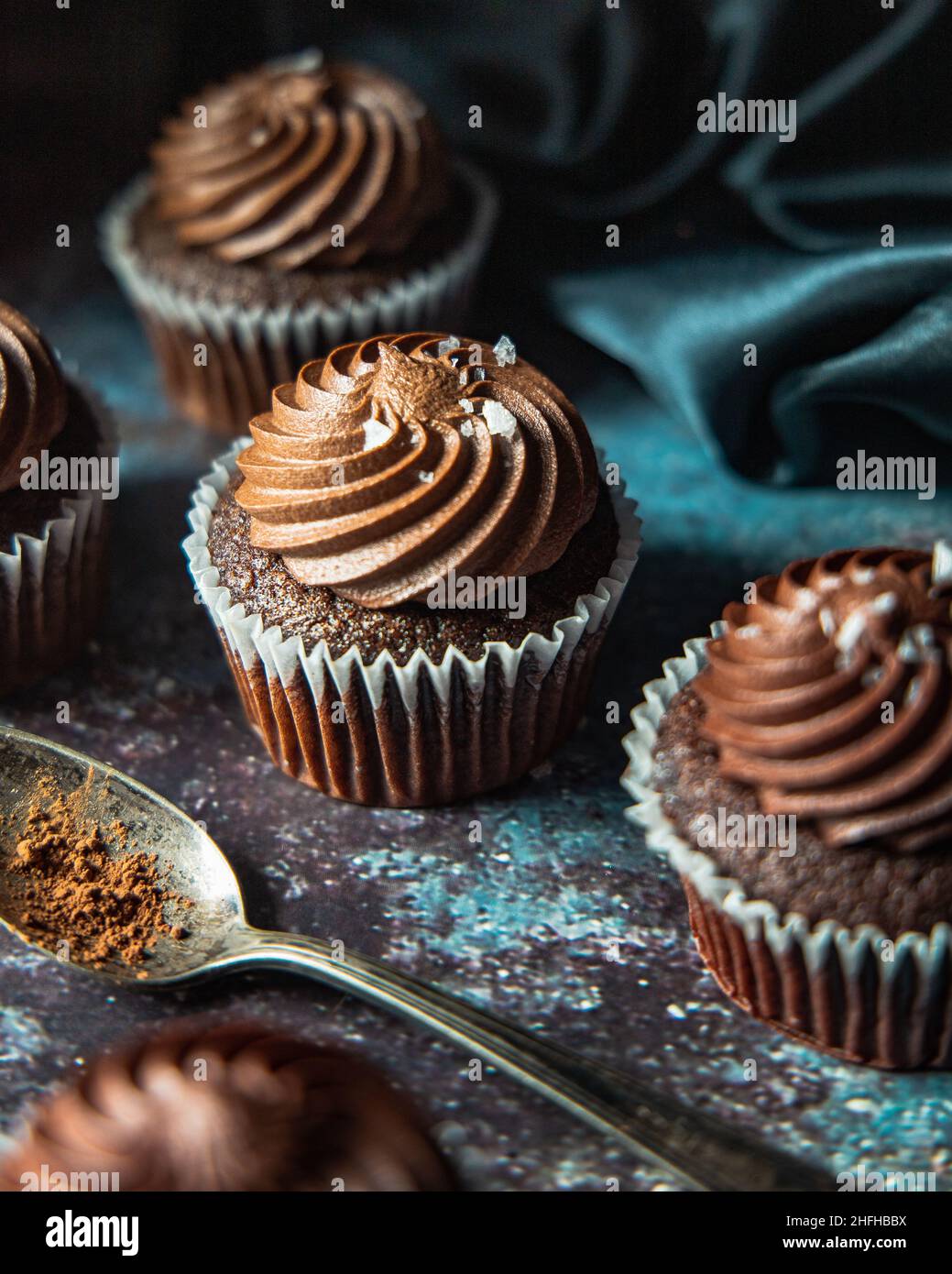 Gourmet and decadent chocolate cupcakes with a dark and moody backdrop Stock Photo