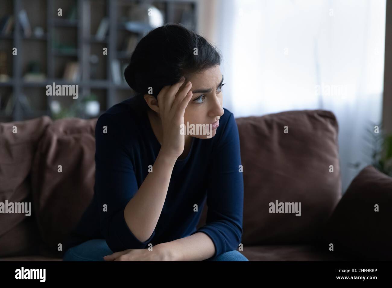 Puzzled unhappy young Indian woman looking in distance. Stock Photo