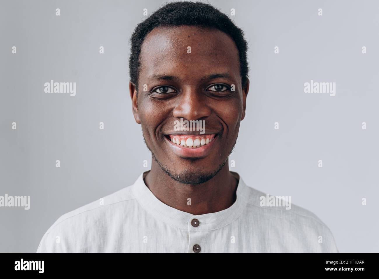 Portrait of handsome positive young African-American man in white shirt ...
