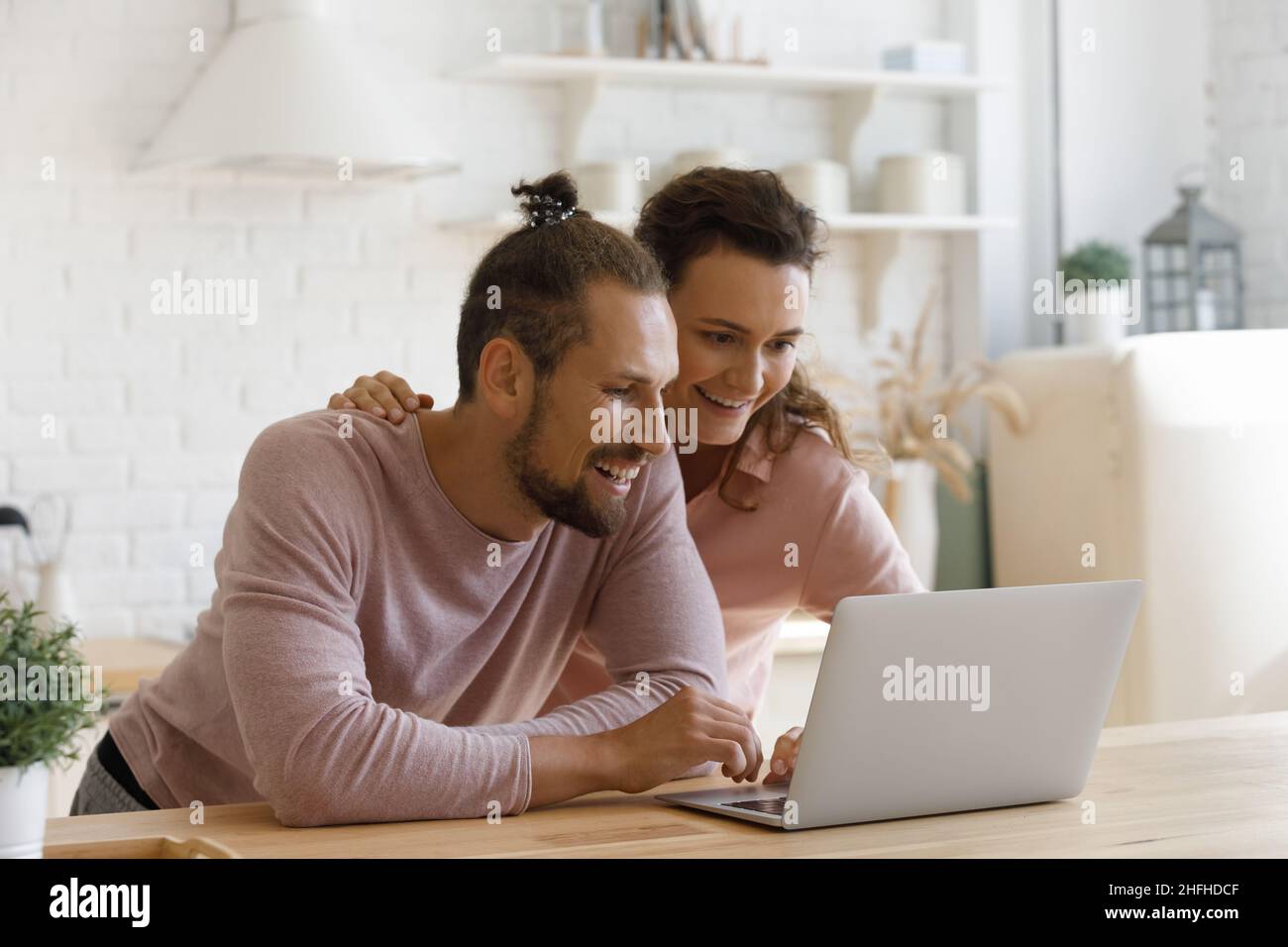 Smiling bonding young family couple using computer Stock Photo - Alamy
