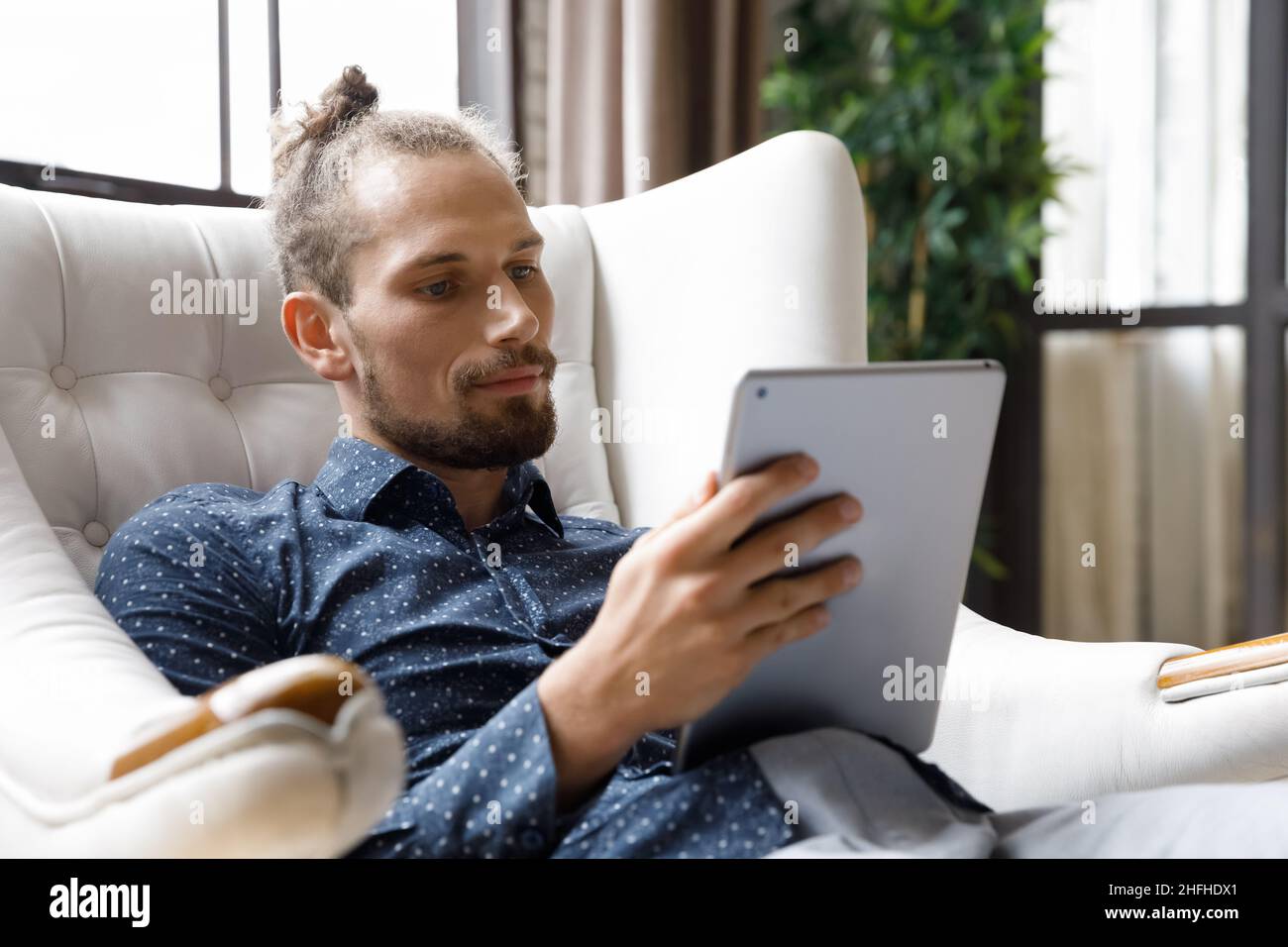 Happy millennial man using digital touchpad gadget Stock Photo - Alamy