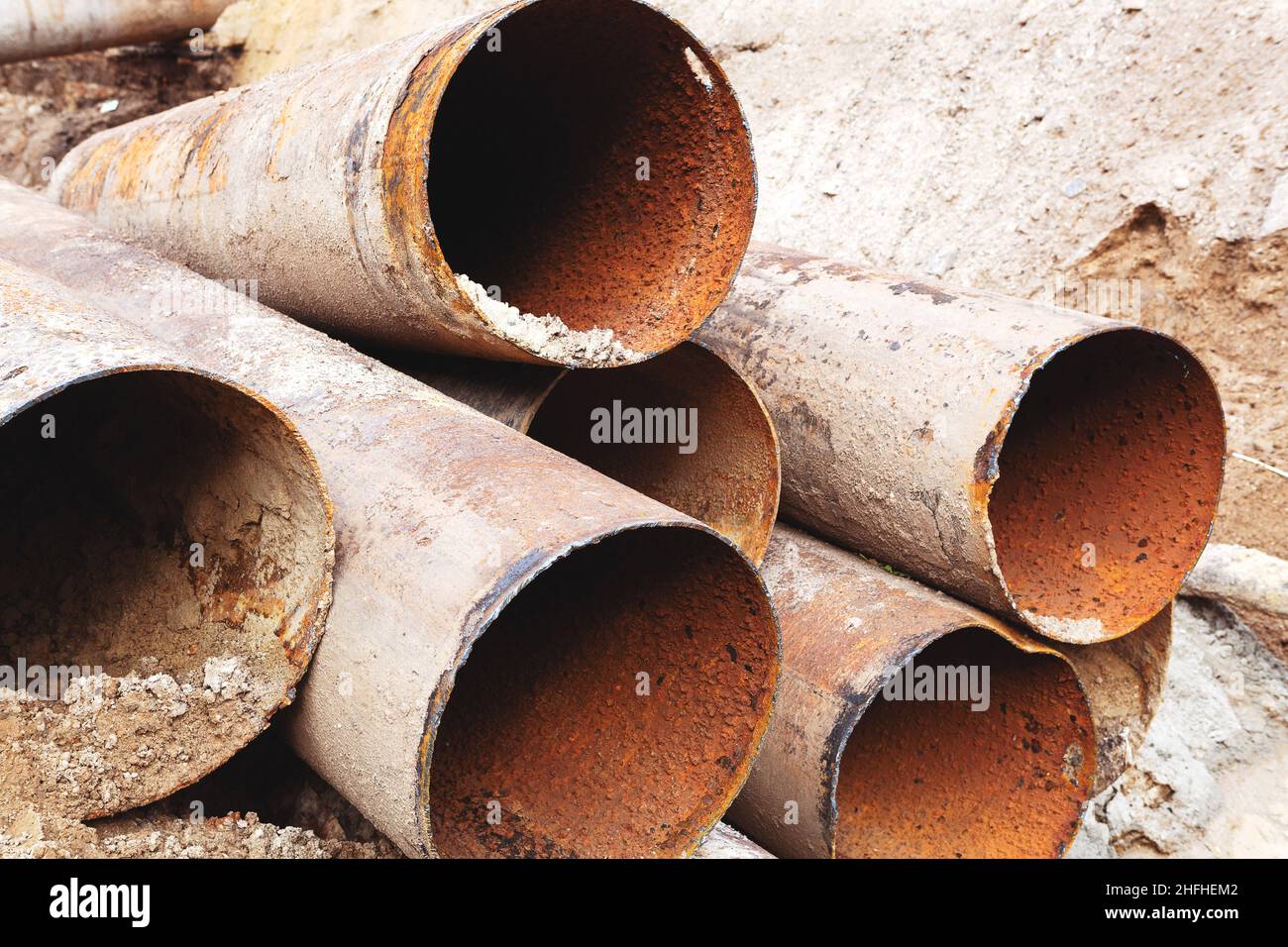 Fragments of old large water pipes. After many years of operation, corroded metal pipe destroyed. Rusty steel tube with holes metal corrosion. Selecti Stock Photo