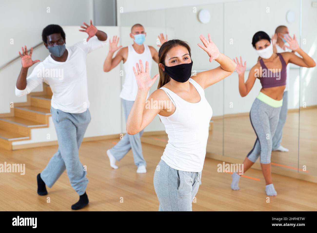 People in masks training in dance studio Stock Photo