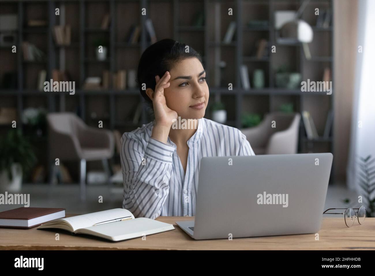 Thoughtful young Indian ethnicity business woman working in office. Stock Photo