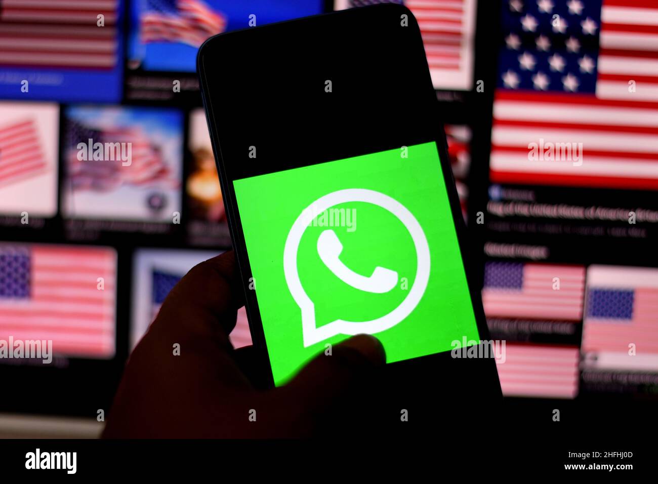 Kolkata, India. 16th Jan, 2022. In this photo illustration, a WhatsApp logo seen displayed on a smartphone with Flags of the United States in the background. (Photo by Avishek Das/SOPA Images/Sipa USA) Credit: Sipa USA/Alamy Live News Stock Photo