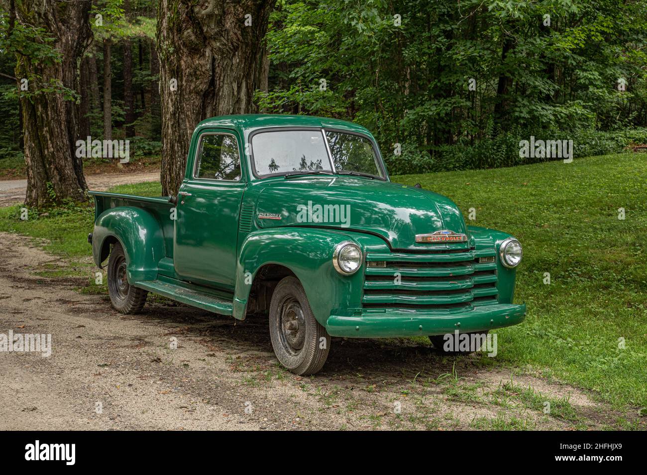 An antique pickup truck parked along a dirt road in New Salem, MA Stock Photo