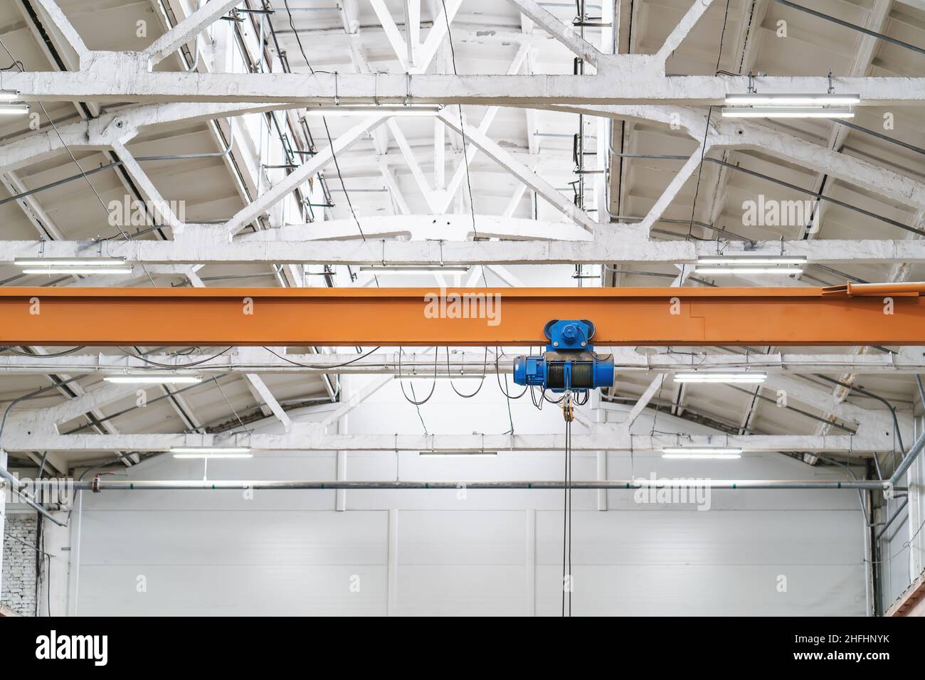 Overhead beam or bridge crane in industrial warehouse hangar building. Stock Photo