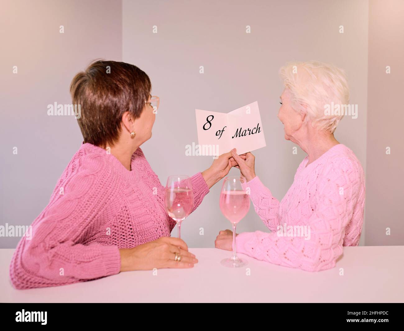 Two mature women drinking wine and giving a post card. Friendship,  holidays, love, same-sex marriage concept Stock Photo - Alamy